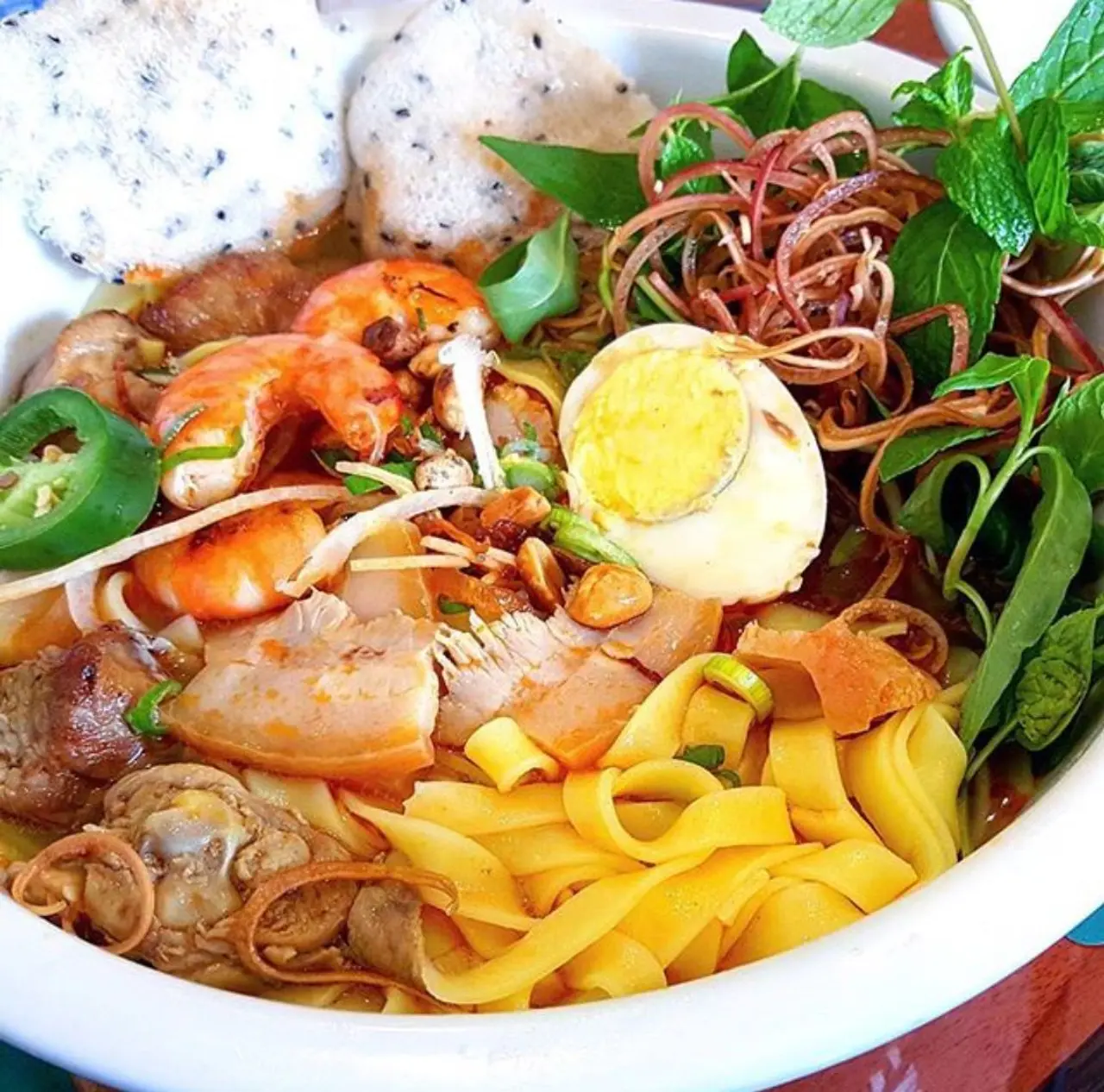 Da Nang Travel Guide 2026: 15 Best Things to Do, Itineraries & Insider Tips for Vietnam's Coastal Gem 11 Mi Quang turmeric noodles Da Nang with shrimp, pork, quail egg, peanuts and sesame rice cracker